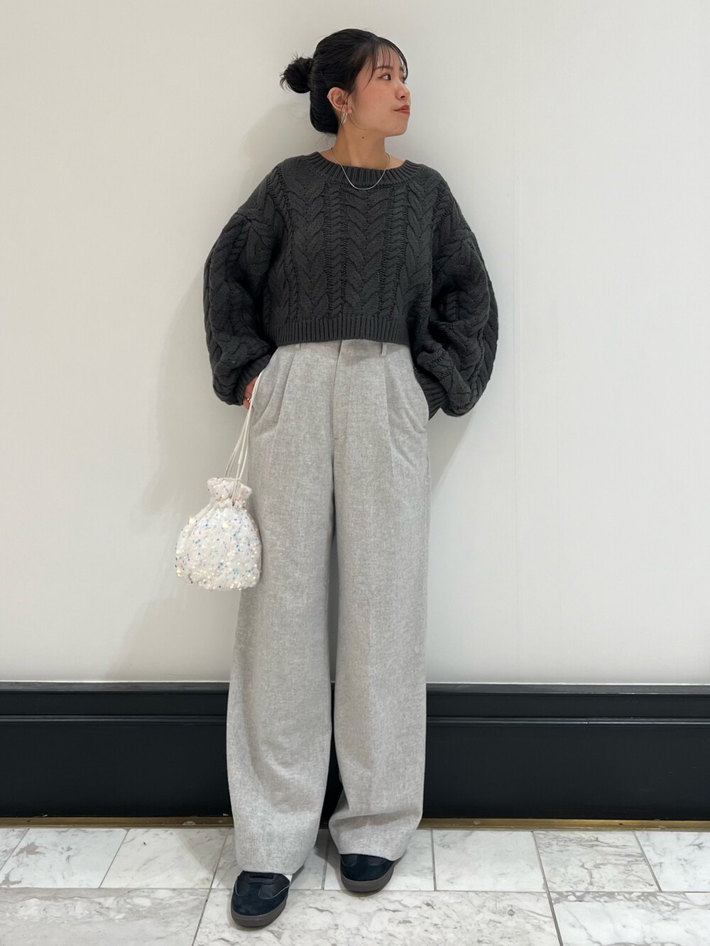 グレー系のその他パンツ、グレー系のニット/セーター、ホワイト系のハンドバッグを着用したレディースの冬コーディネートの6枚目の写真