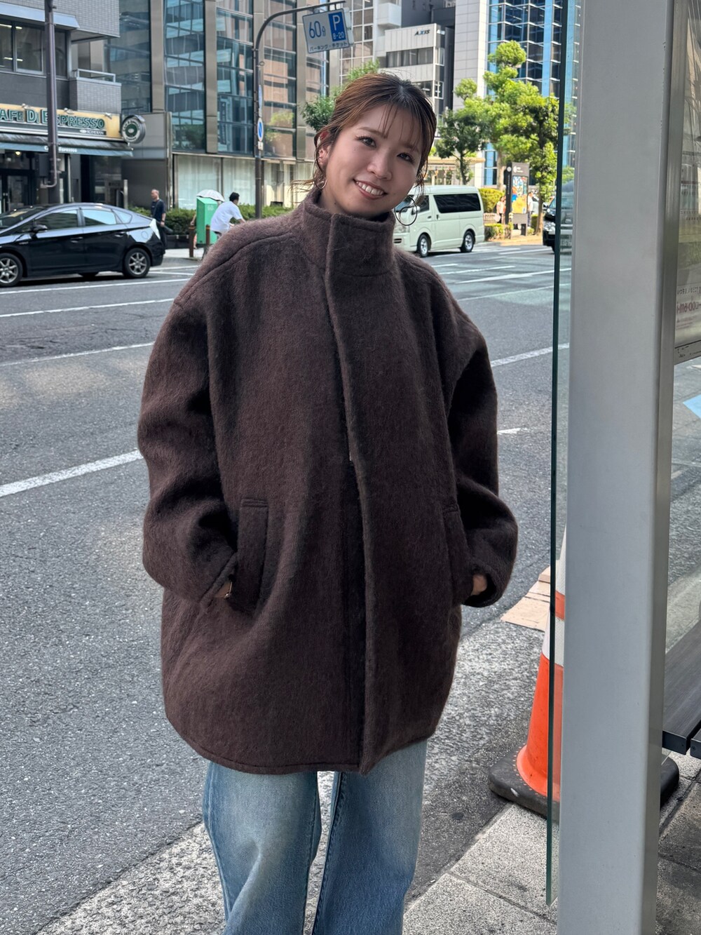 ブラウン系のダウンジャケット/コート、ブルー系のデニムパンツ、ブラウン系のブーツを着用したレディースの秋コーディネートの8枚目の写真