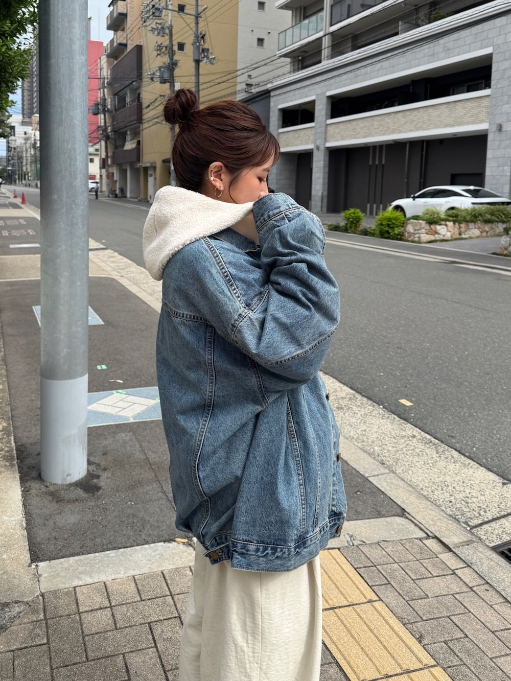 ブルー系のデニムジャケット、ホワイト系のパーカー、ホワイト系のその他パンツを着用したレディースの秋コーディネートの8枚目の写真