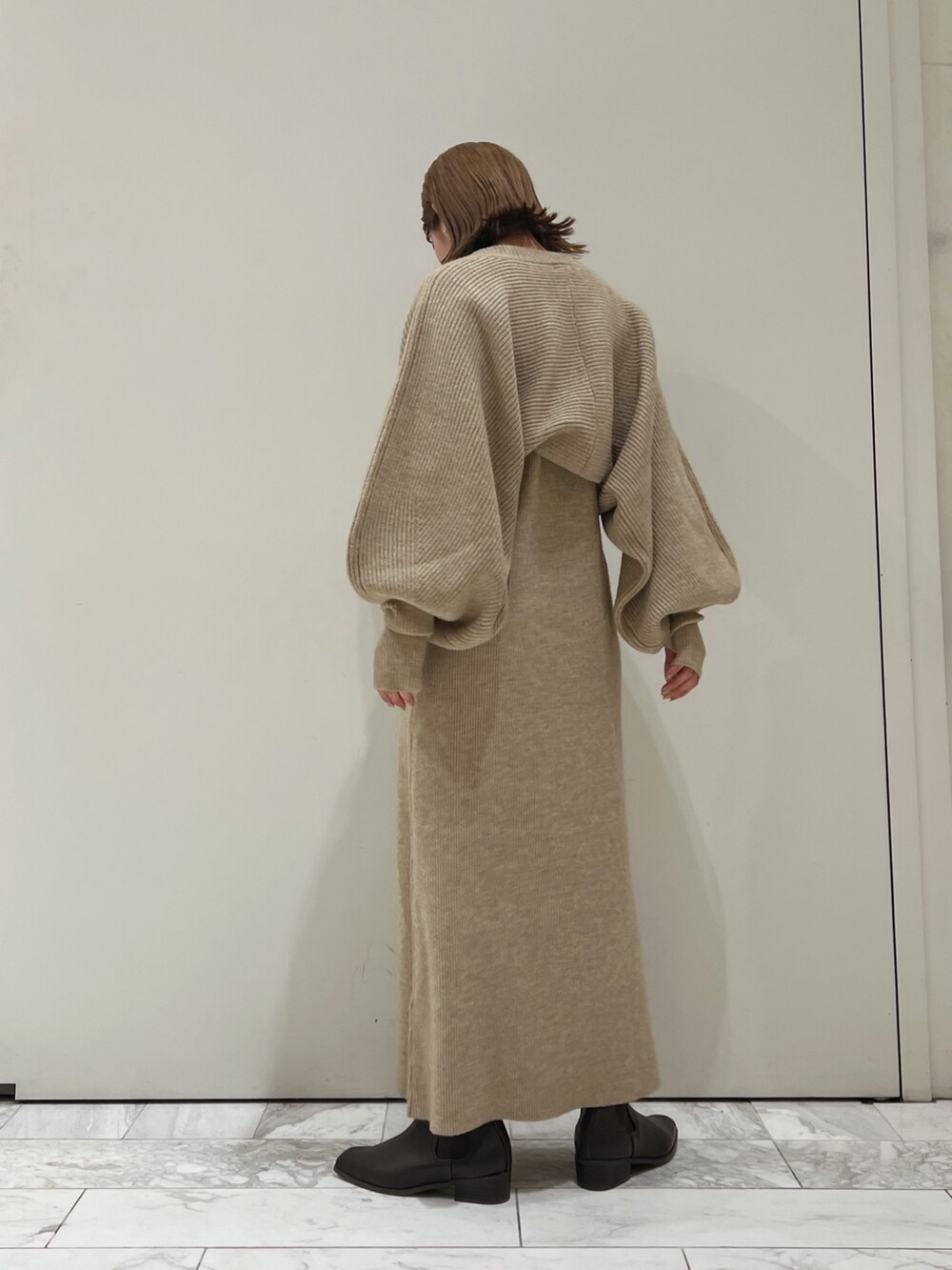 グレー系のワンピース、ブラウン系のブーツを着用したレディースの秋コーディネートの6枚目の写真