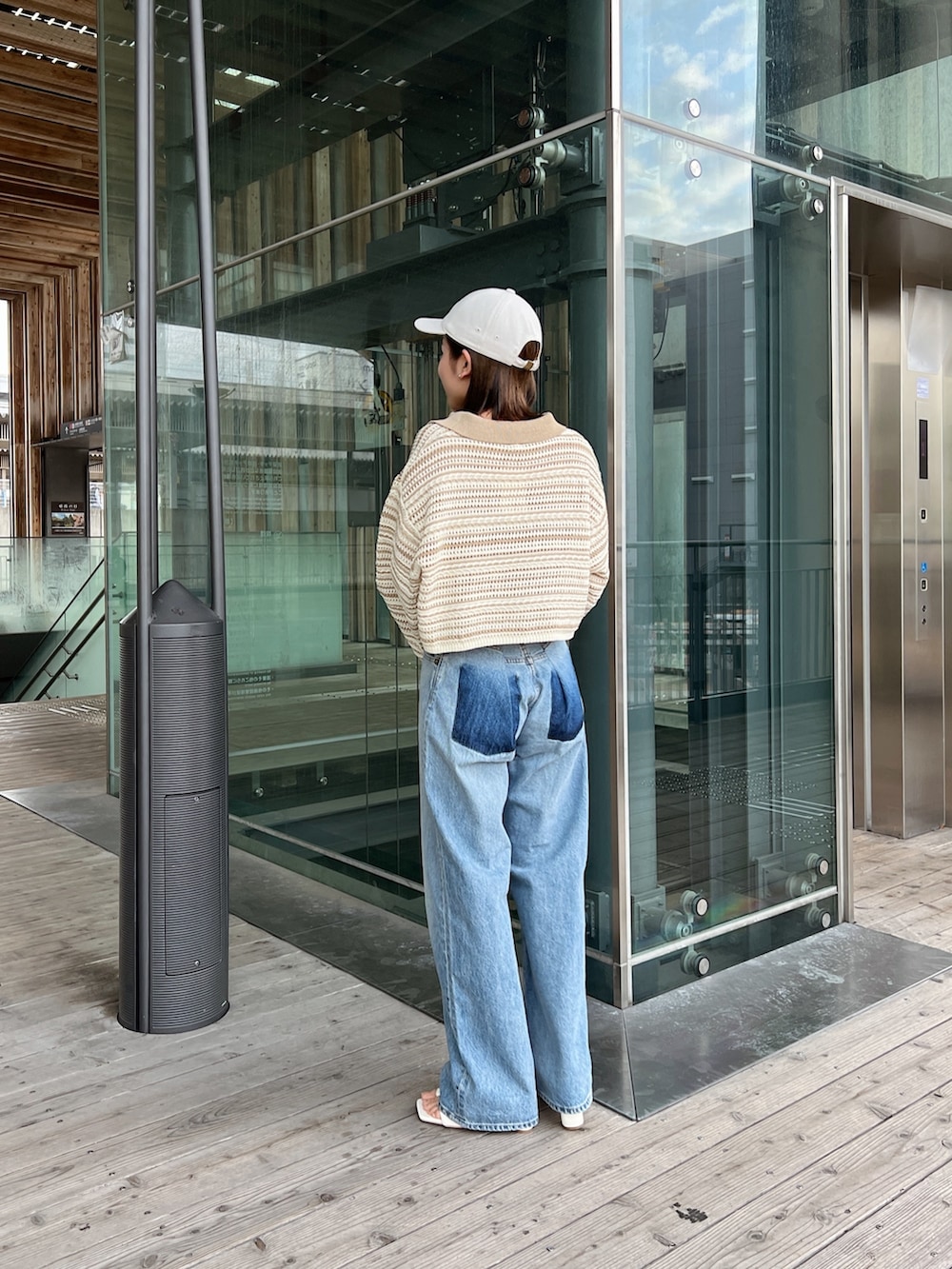 ベージュ系のニット/セーター、ブルー系のデニムパンツ、ホワイト系のサンダルを着用したレディースの春コーディネートの6枚目の写真