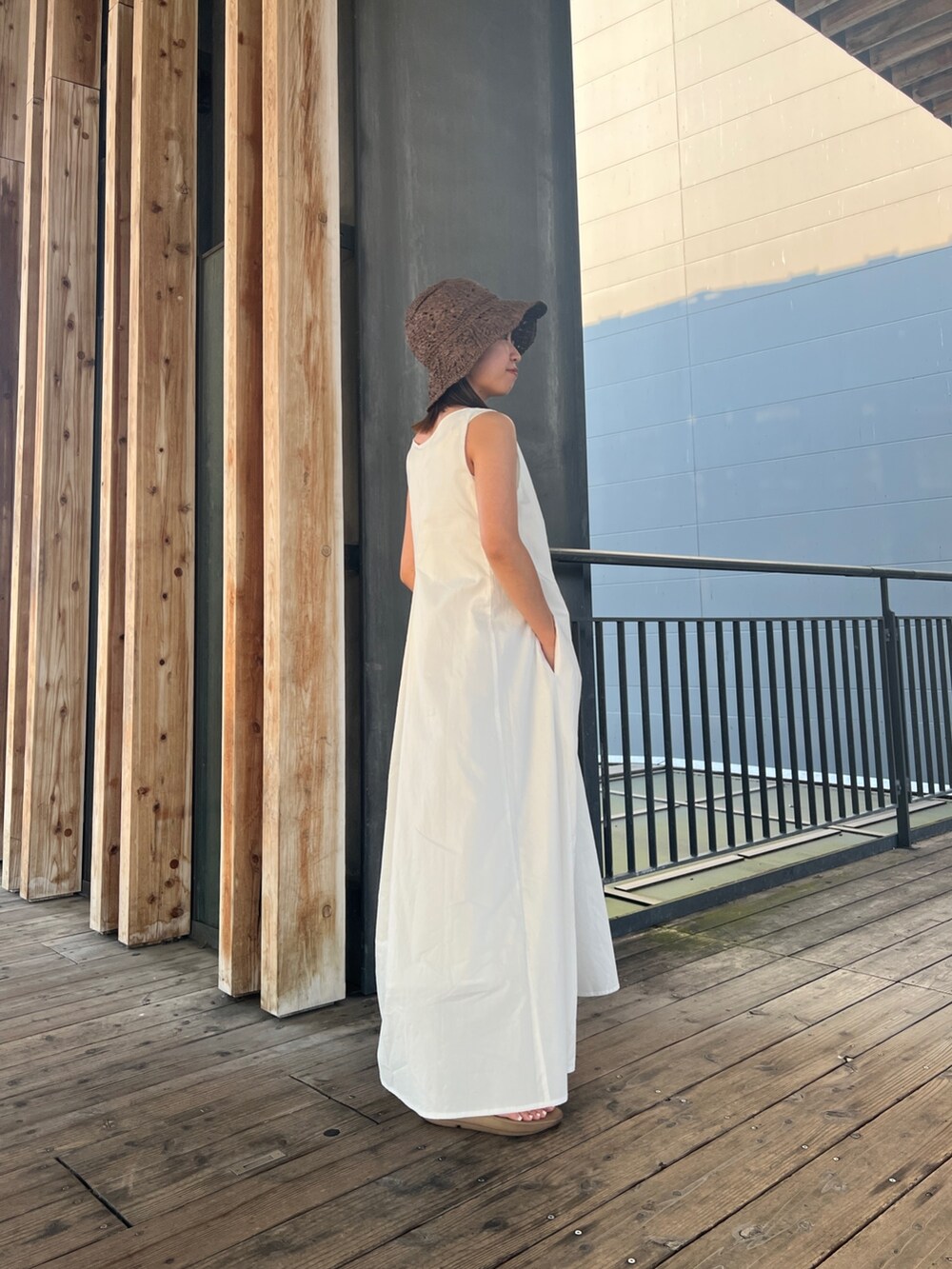 ホワイト系のワンピース、ブルー系のデニムパンツ、ブラウン系のハットを着用したレディースの夏コーディネートの5枚目の写真