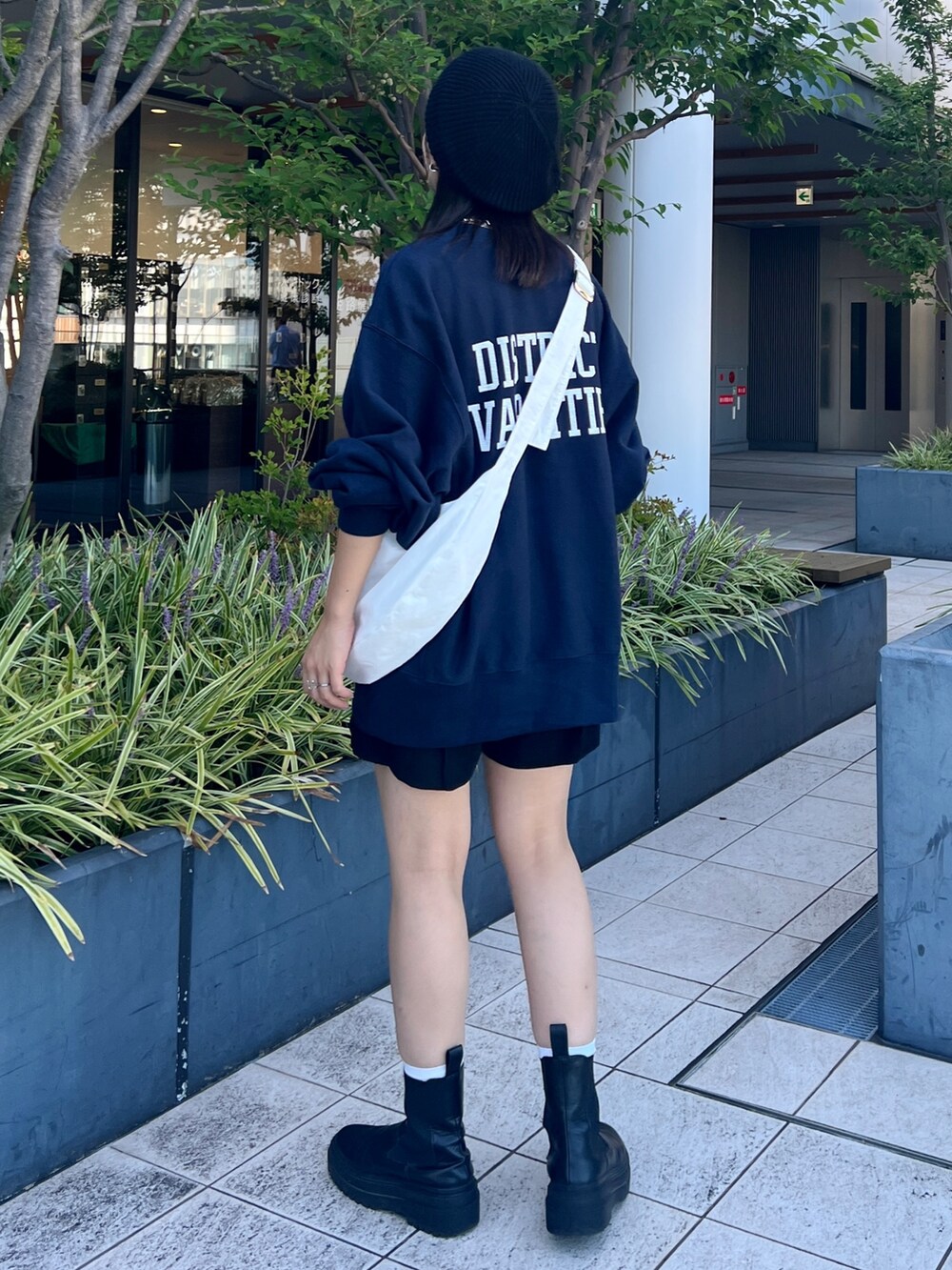 ブルー系のスウェット、ホワイト系のショルダーバッグ、ブラック系のハンチング/ベレー帽を着用したレディースの秋コーディネートの4枚目の写真