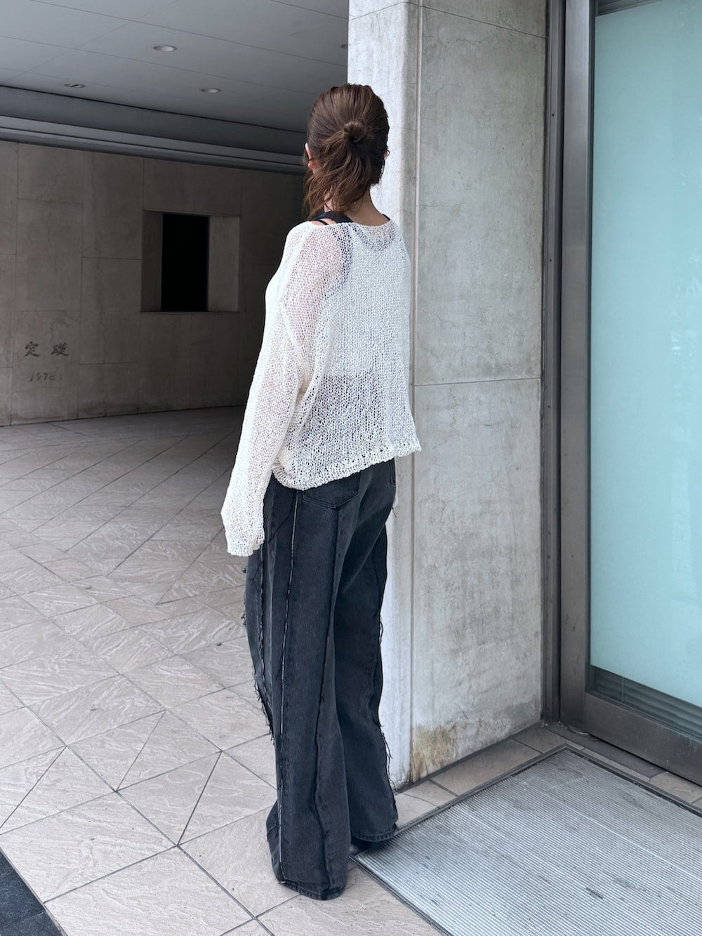 ブラック系のデニムパンツ、ホワイト系のタンクトップ、ホワイト系のニット/セーターを着用したレディースの夏コーディネートの4枚目の写真