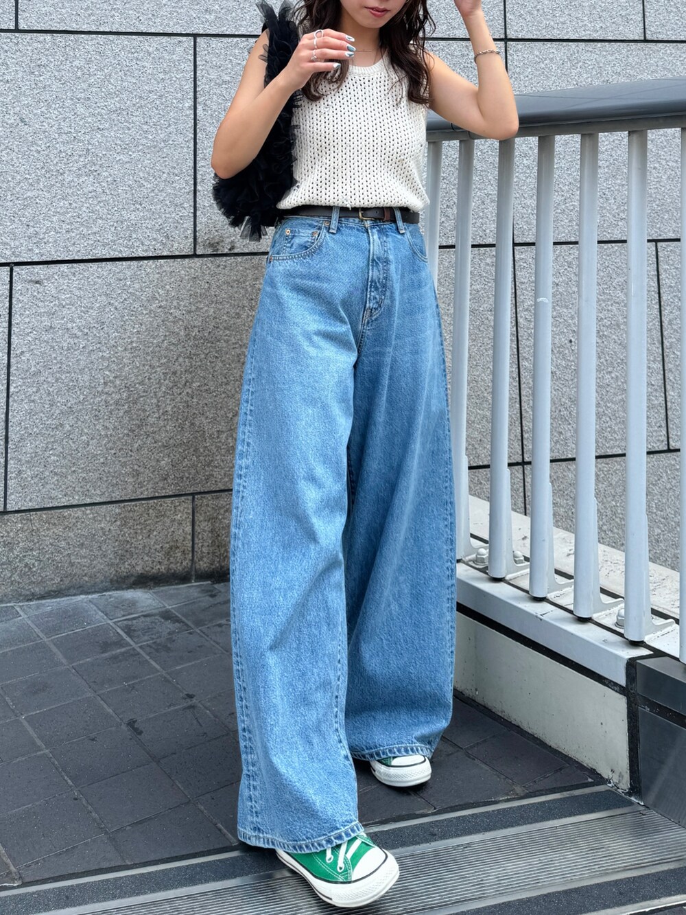 ブルー系のデニムパンツ、ホワイト系のニット/セーター、ブラック系のショルダーバッグを着用したレディースの秋コーディネートの4枚目の写真