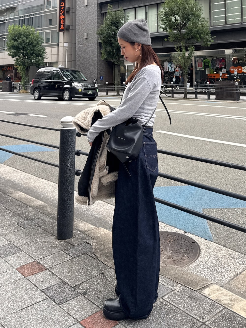 グレー系のニット/セーター、ブルー系のデニムパンツ、グレー系のニットキャップ/ビーニーを着用したレディースの秋コーディネートの5枚目の写真
