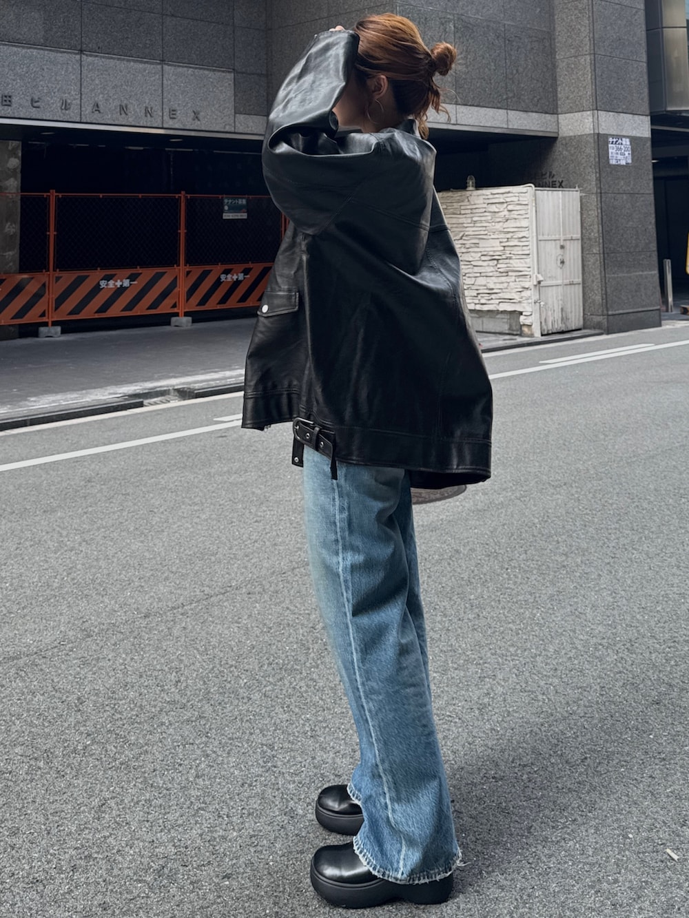ブラック系のブルゾン、ブルー系のデニムパンツを着用したレディースの秋コーディネートの5枚目の写真