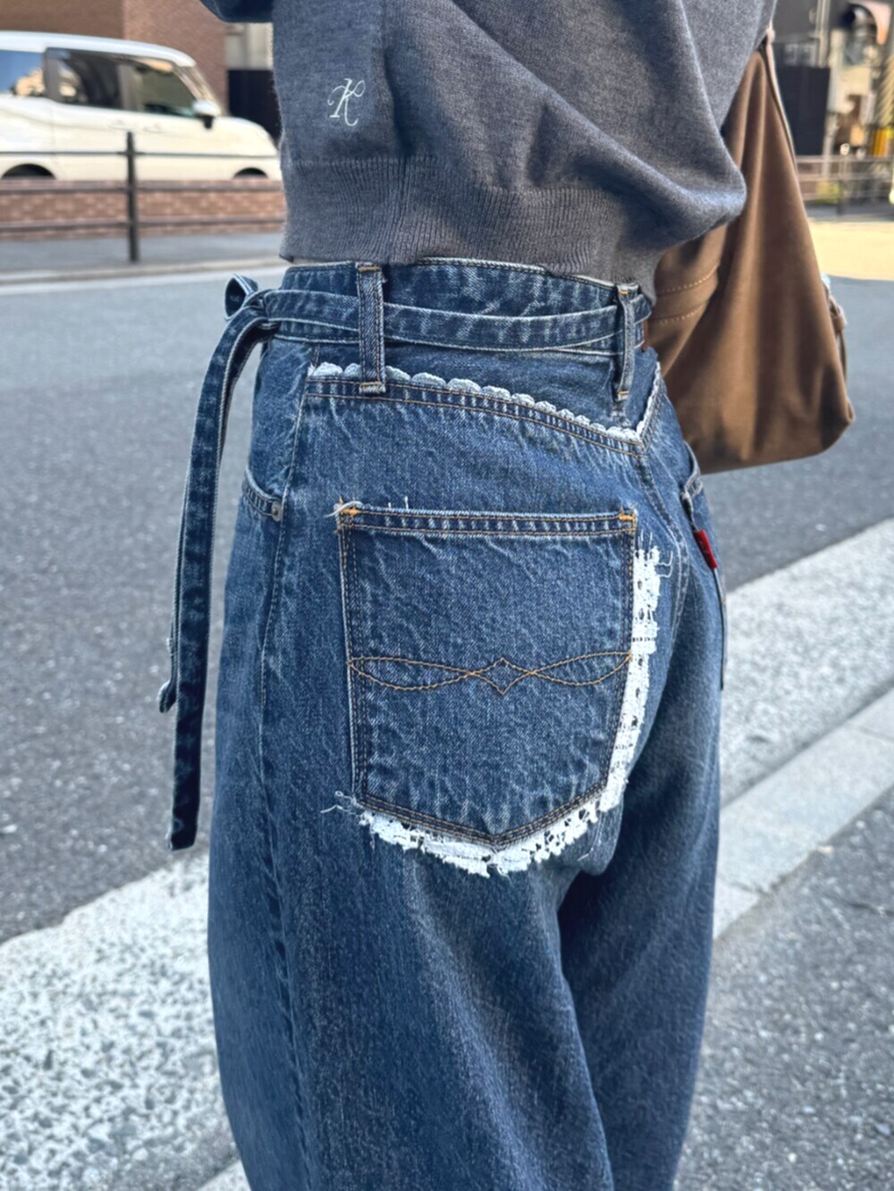 ベージュ系のスリッポン、グレー系のカーディガン/ボレロ、ブルー系のデニムパンツを着用したレディースの夏コーディネートの10枚目の写真