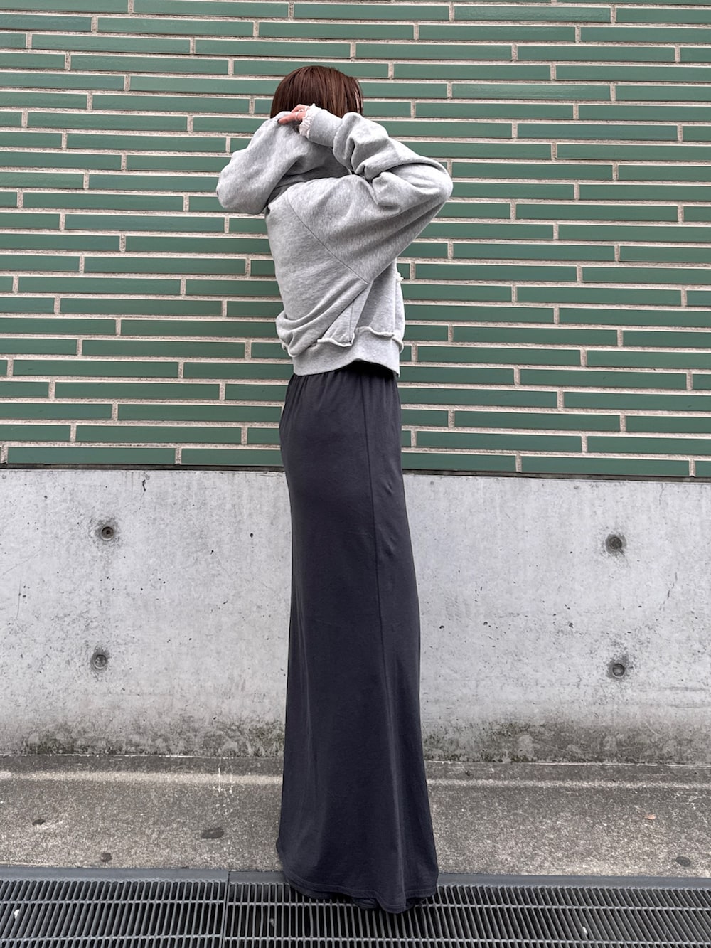 グレー系のパーカー、ホワイト系のTシャツ/カットソー、グレー系のスカートを着用したレディースの冬コーディネートの4枚目の写真