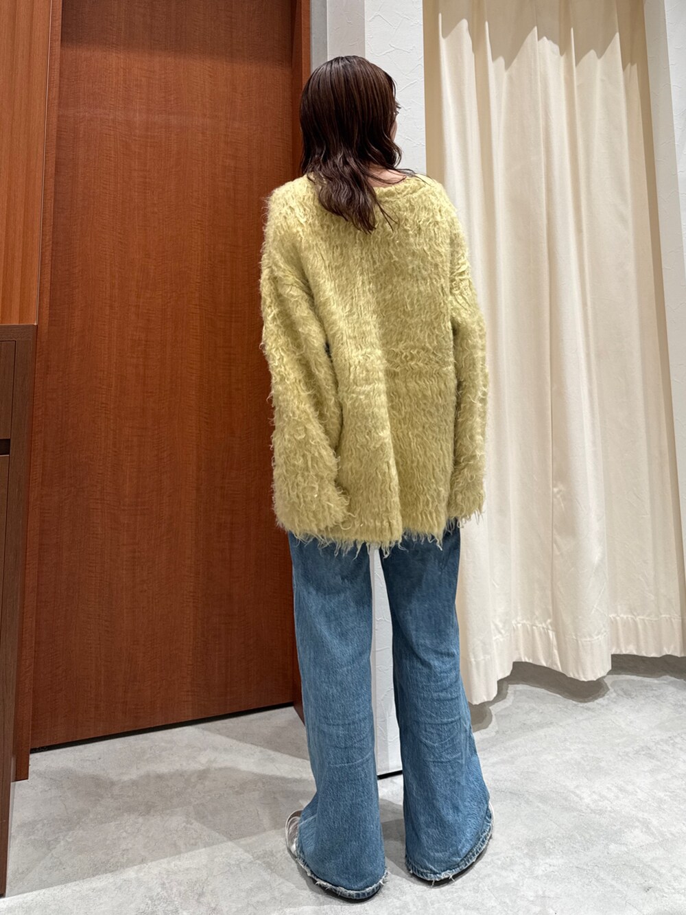 ブルー系のデニムパンツ、イエロー系のカーディガン/ボレロを着用したレディースの秋コーディネートの4枚目の写真