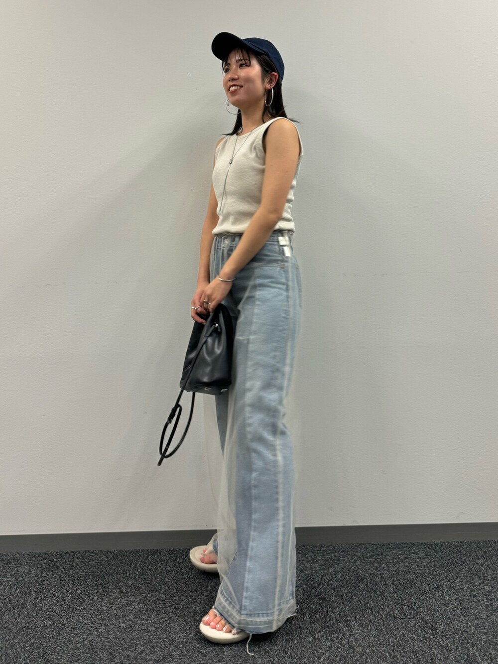 ブルー系のデニムパンツ、ベージュ系のその他パンツ、ホワイト系のタンクトップを着用したレディースの春コーディネートの2枚目の写真