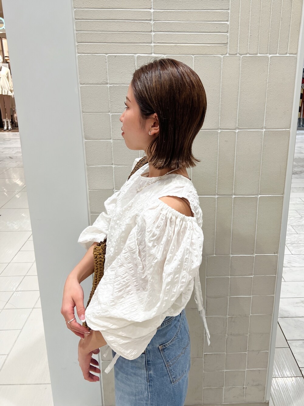 ホワイト系のシャツ/ブラウス、ブラウン系のトートバッグ、ブルー系のデニムパンツを着用したレディースの冬コーディネートの8枚目の写真