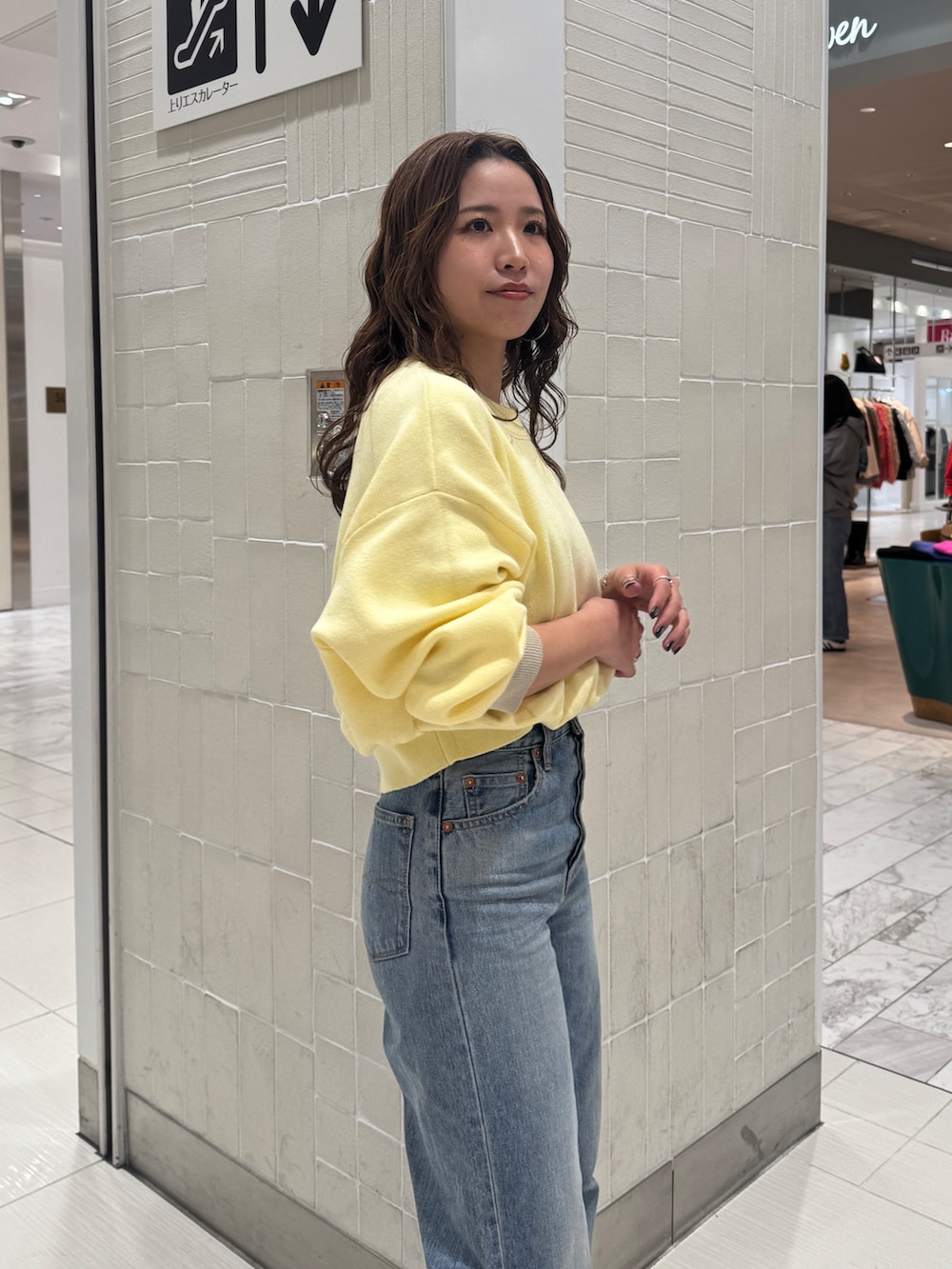 ブルー系のデニムパンツ、ブラック系のブルゾン、イエロー系のニット/セーターを着用したレディースの冬コーディネートの8枚目の写真