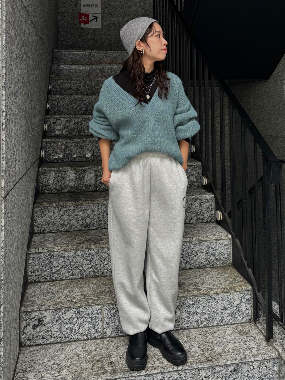 ブラック系のTシャツ/カットソー、グレー系のスウェットパンツ、ブルー系のニット/セーターを着用したレディースの秋コーディネートの2枚目の写真
