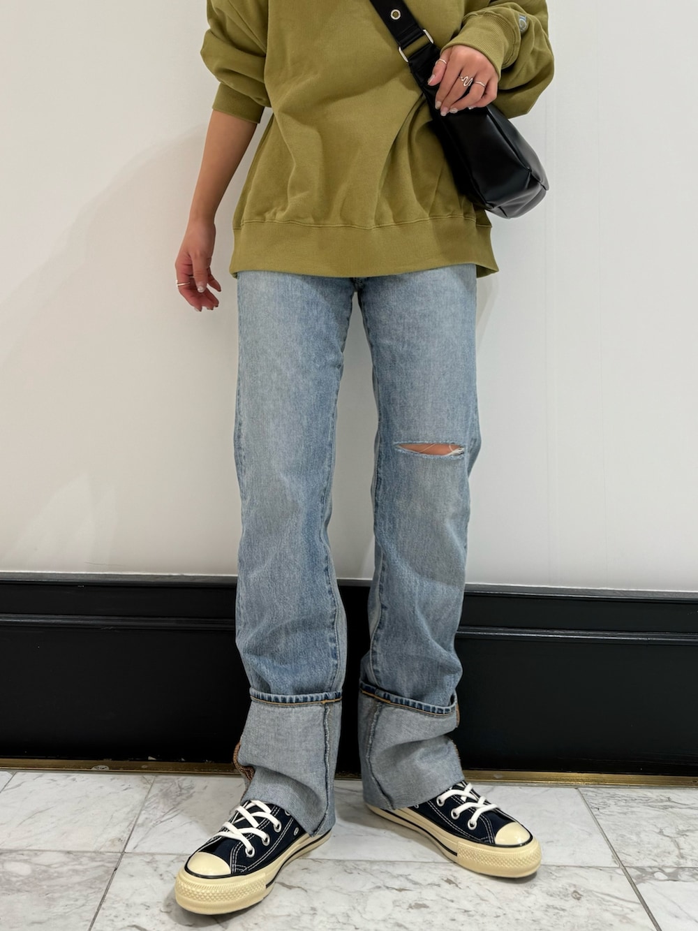 グリーン系のスウェット、ブラック系のショルダーバッグ、イエロー系のTシャツ/カットソーを着用したレディースの冬コーディネートの8枚目の写真