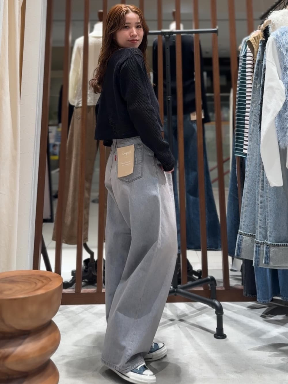 ブルー系のデニムパンツ、ブラック系のカーディガン/ボレロ、パープル系のTシャツ/カットソーを着用したレディースの春コーディネートの3枚目の写真