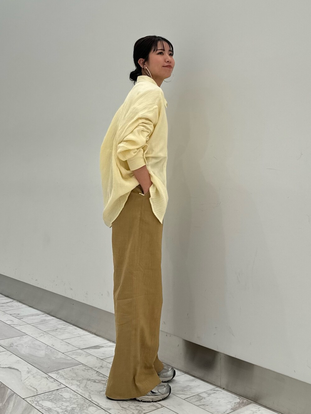 ベージュ系のその他パンツ、ホワイト系のキャミソール、イエロー系のシャツ/ブラウスを着用したレディースの春コーディネートの4枚目の写真