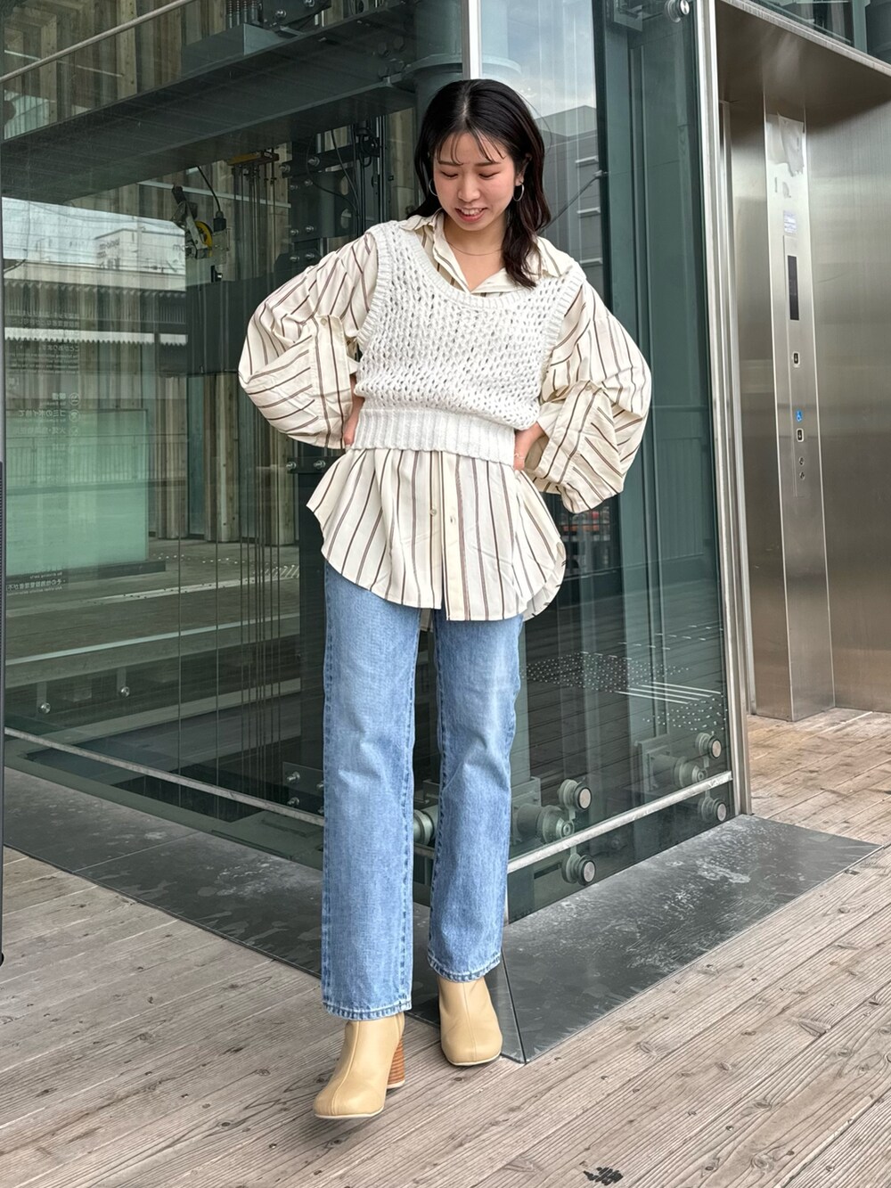 ベージュ系のブーツ、ブルー系のデニムパンツ、イエロー系のシャツ/ブラウスを着用したレディースの冬コーディネートの4枚目の写真