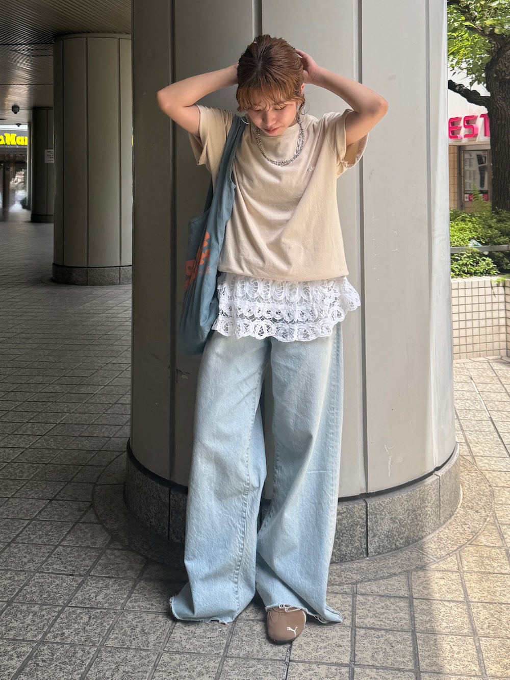 ブルー系のデニムパンツ、ブルー系のトートバッグ、ホワイト系のシャツ/ブラウスを着用したレディースの夏コーディネートの2枚目の写真