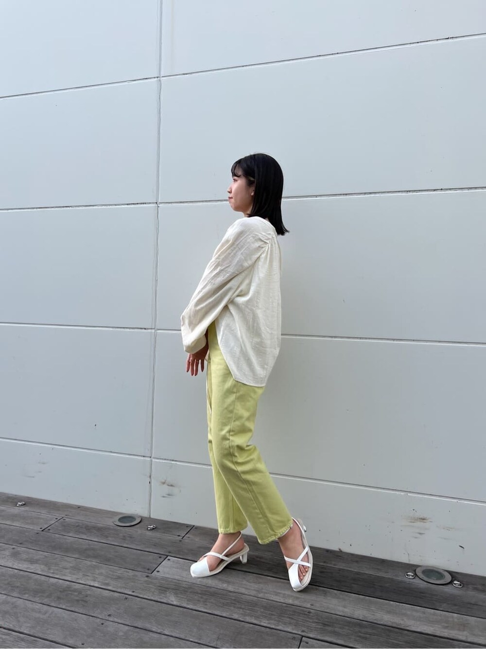 グリーン系のデニムパンツ、ホワイト系のシャツ/ブラウス、ホワイト系のサンダルを着用したレディースの春コーディネートの3枚目の写真