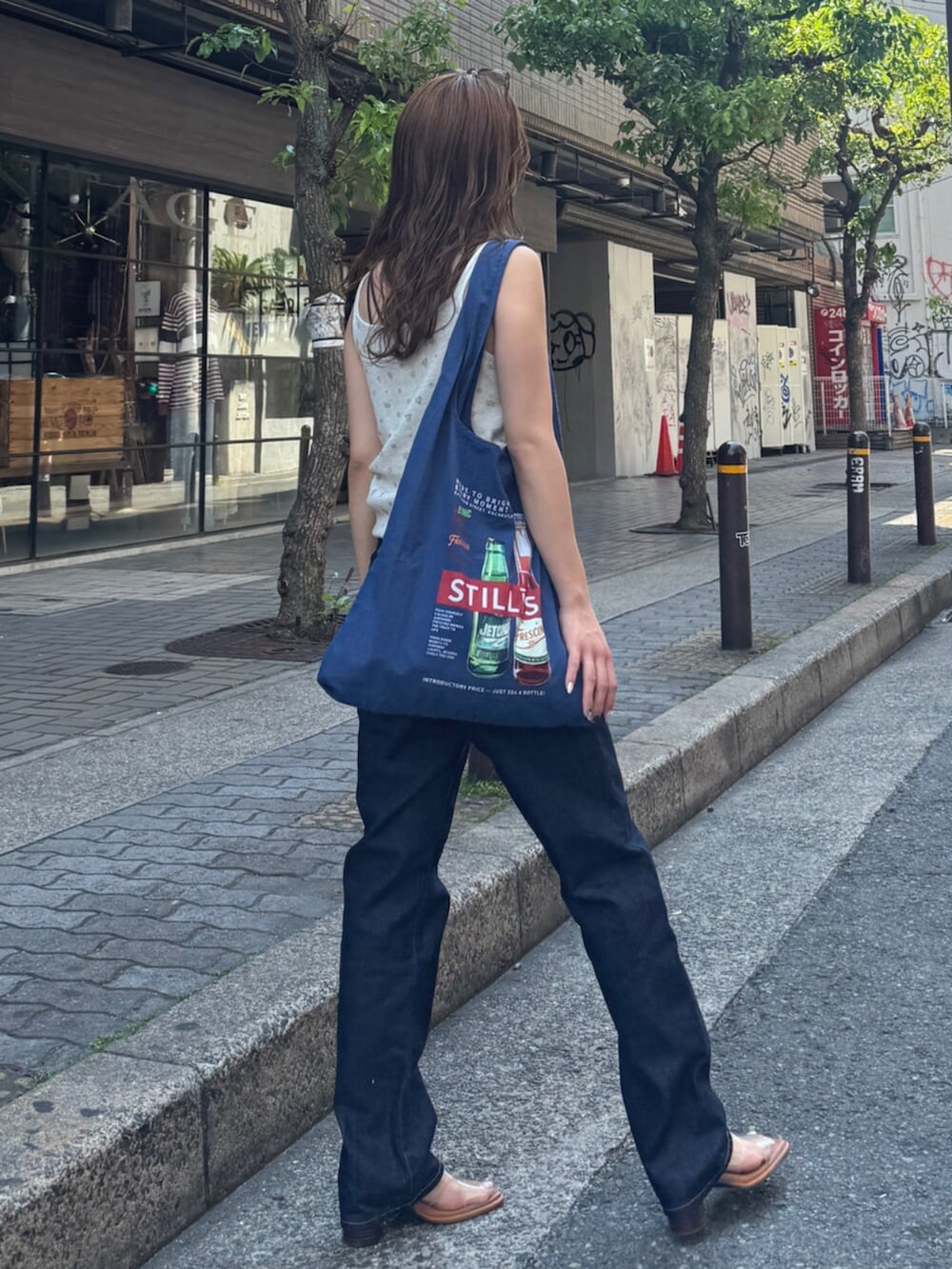 ブルー系のデニムパンツ、その他のサンダル、ブルー系のトートバッグを着用したレディースの春コーディネートの6枚目の写真