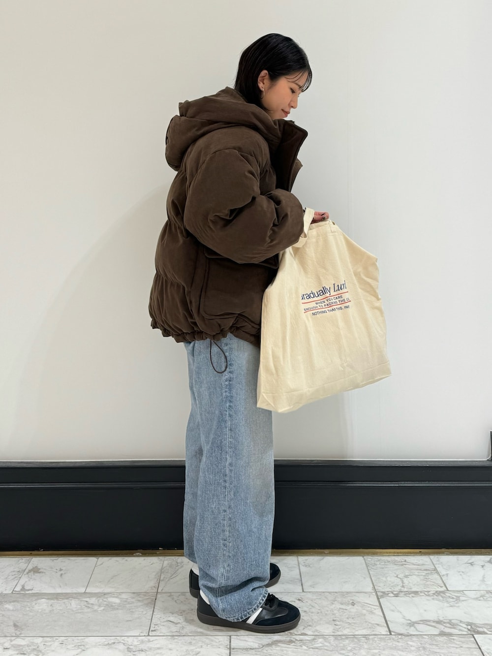 ブルー系のデニムパンツ、ホワイト系のトートバッグ、ホワイト系のTシャツ/カットソーを着用したレディースの冬コーディネートの6枚目の写真