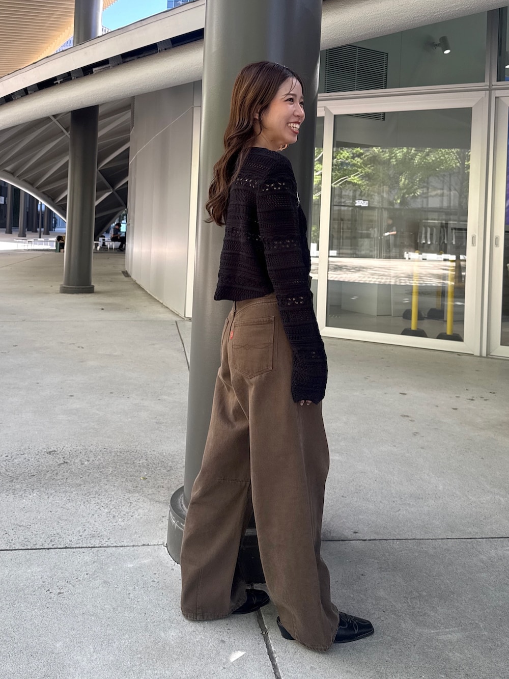 ブラウン系のデニムパンツ、ブラック系のその他シューズ、ブラック系のニット/セーターを着用したレディースの秋コーディネートの3枚目の写真