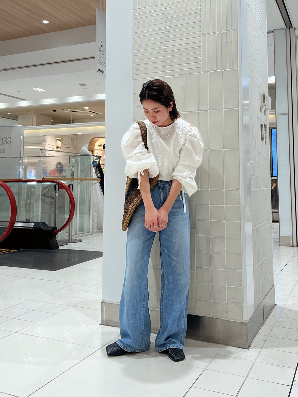 ホワイト系のシャツ/ブラウス、ブラウン系のトートバッグ、ブルー系のデニムパンツを着用したレディースの冬コーディネートの6枚目の写真