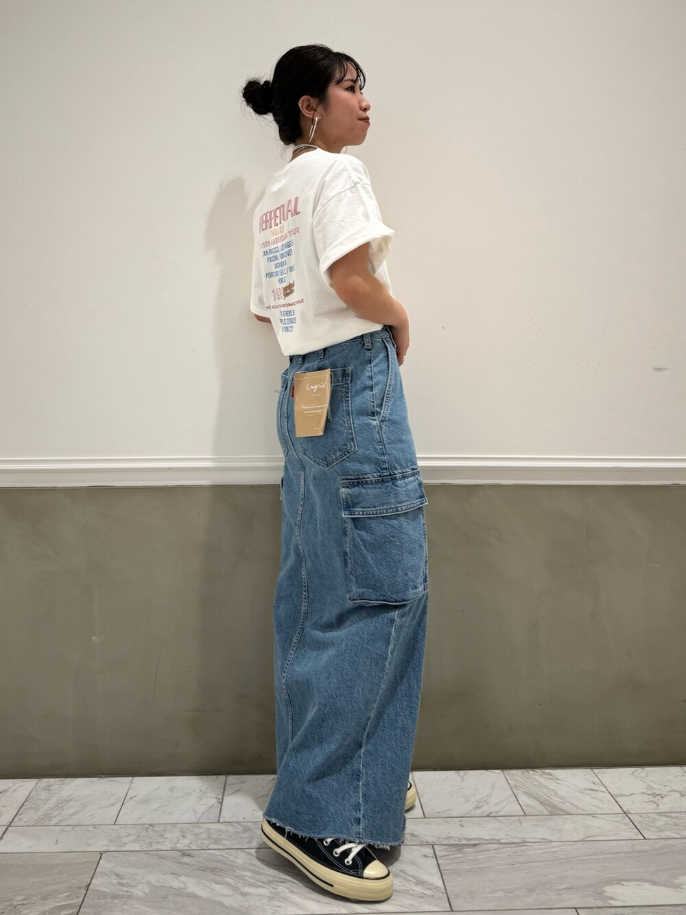 ブルー系のデニムスカート、ホワイト系のTシャツ/カットソー、ブルー系のスニーカーを着用したレディースの春コーディネートの4枚目の写真