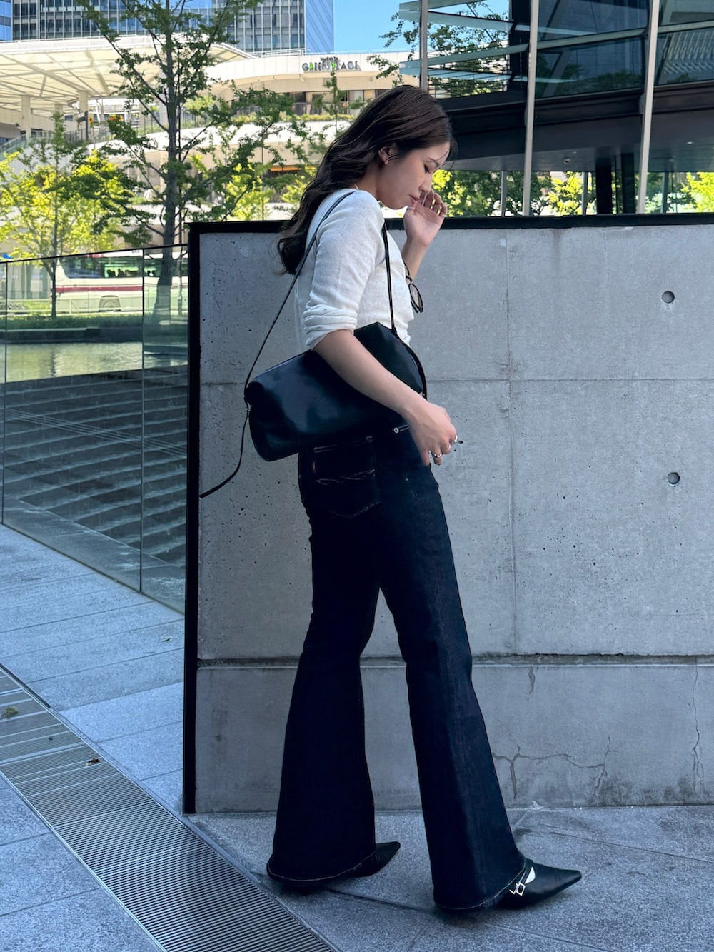 ホワイト系のニット/セーター、ブルー系のデニムパンツ、ブラック系のパンプスを着用したレディースの秋コーディネートの3枚目の写真