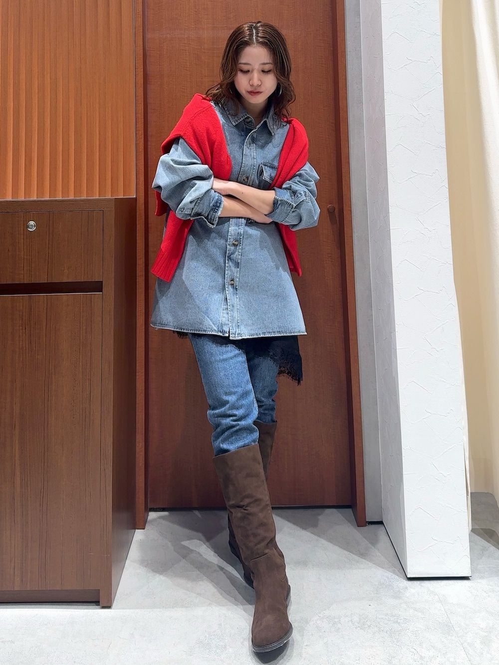 ブルー系のシャツ/ブラウス、レッド系のニット/セーター、ブラック系のキャミソールを着用したレディースの冬コーディネートの2枚目の写真