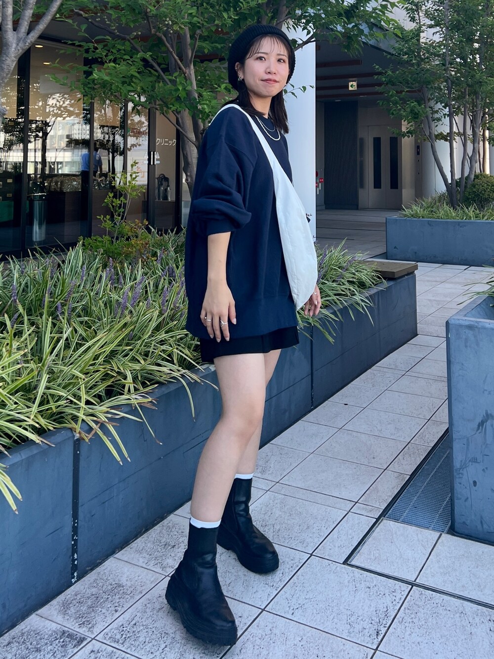 ブルー系のスウェット、ホワイト系のショルダーバッグ、ブラック系のハンチング/ベレー帽を着用したレディースの秋コーディネートの3枚目の写真