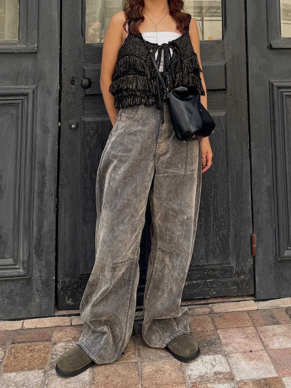 ベージュ系のデニムパンツ、ブラック系のニット/セーター、ベージュ系のスリッポンを着用したレディースの秋コーディネートの2枚目の写真