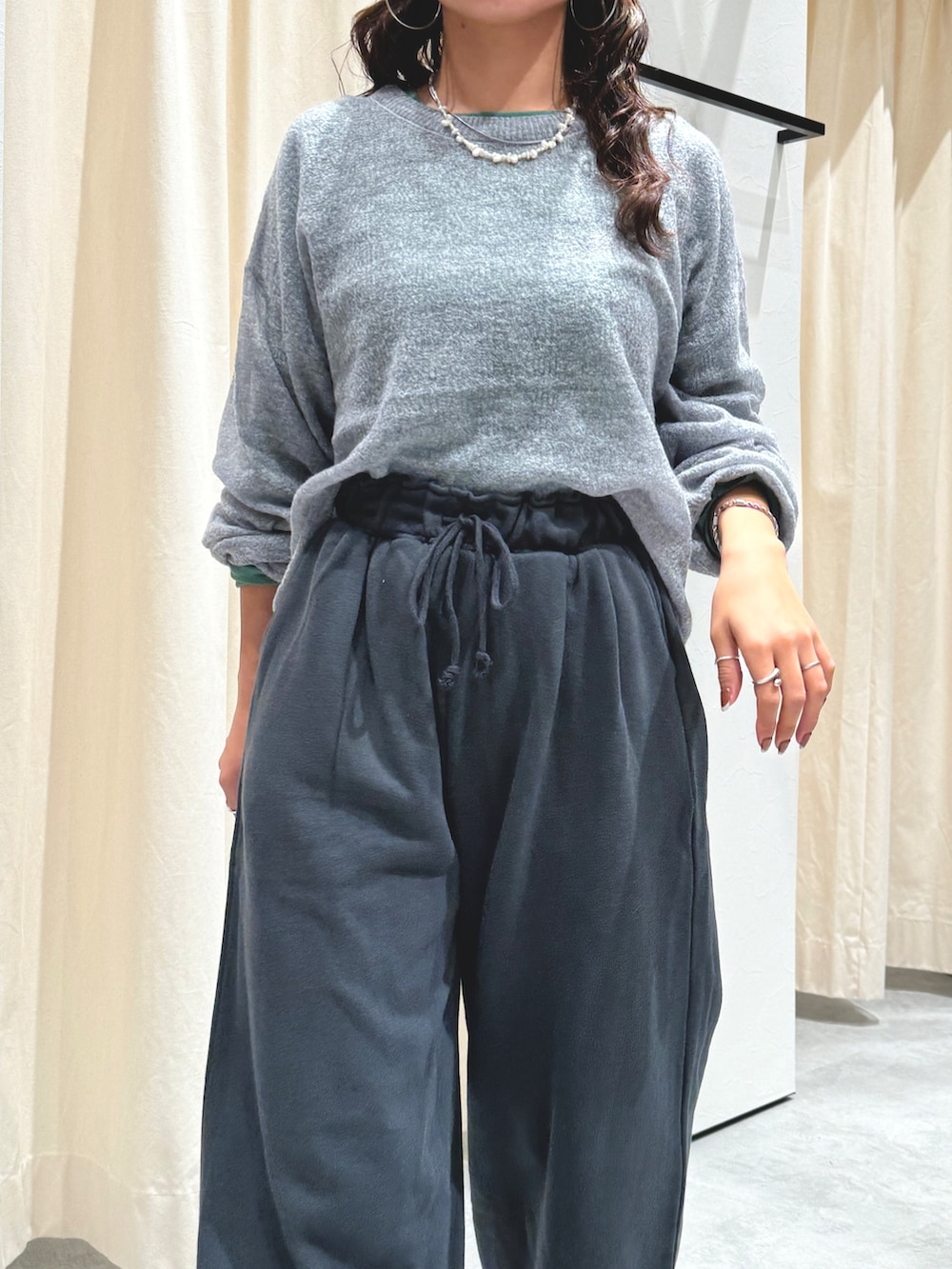 グレー系のニット/セーター、グリーン系のTシャツ/カットソー、グレー系のスウェットパンツを着用したレディースの秋コーディネートの6枚目の写真