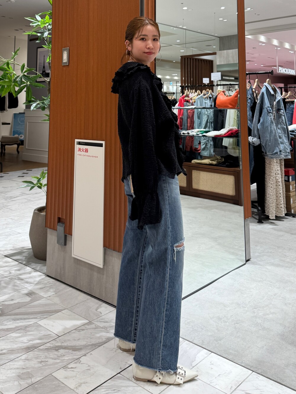 ブルー系のデニムパンツ、ブラック系のシャツ/ブラウス、ホワイト系のパンプスを着用したレディースの春コーディネートの2枚目の写真