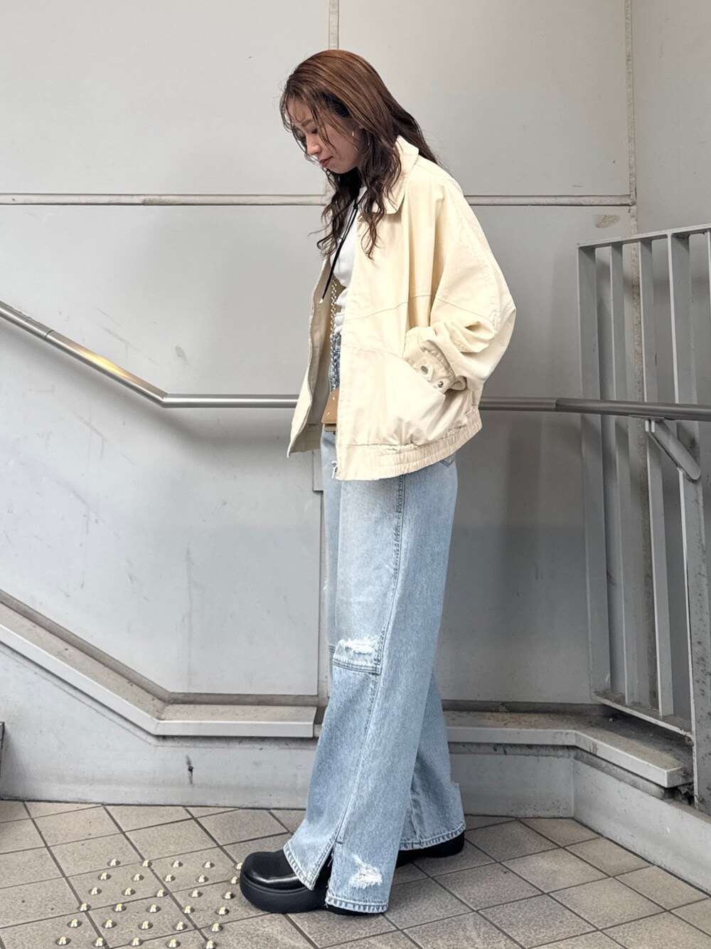 ブルー系のデニムパンツ、ベージュ系のブルゾン、ホワイト系のTシャツ/カットソーを着用したレディースの冬コーディネートの4枚目の写真