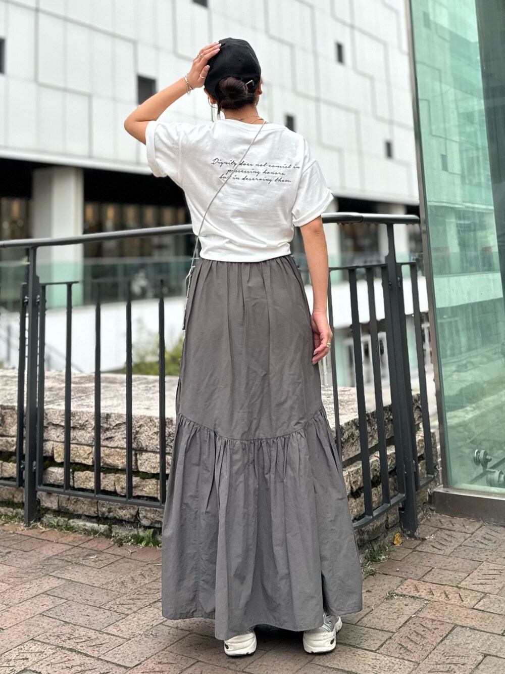 シルバー系のショルダーバッグ、ホワイト系のTシャツ/カットソー、グレー系のスカートを着用したレディースの春コーディネートの4枚目の写真