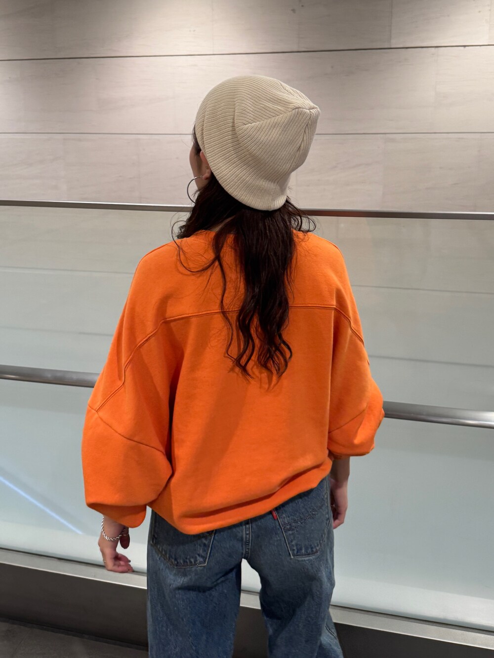 ブルー系のデニムパンツ、オレンジ系のスウェットを着用したレディースの冬コーディネートの5枚目の写真