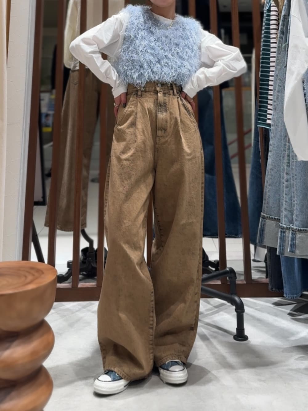 ブラウン系のデニムパンツ、ブルー系のニット/セーター、ホワイト系のTシャツ/カットソーを着用したレディースの春コーディネートの2枚目の写真