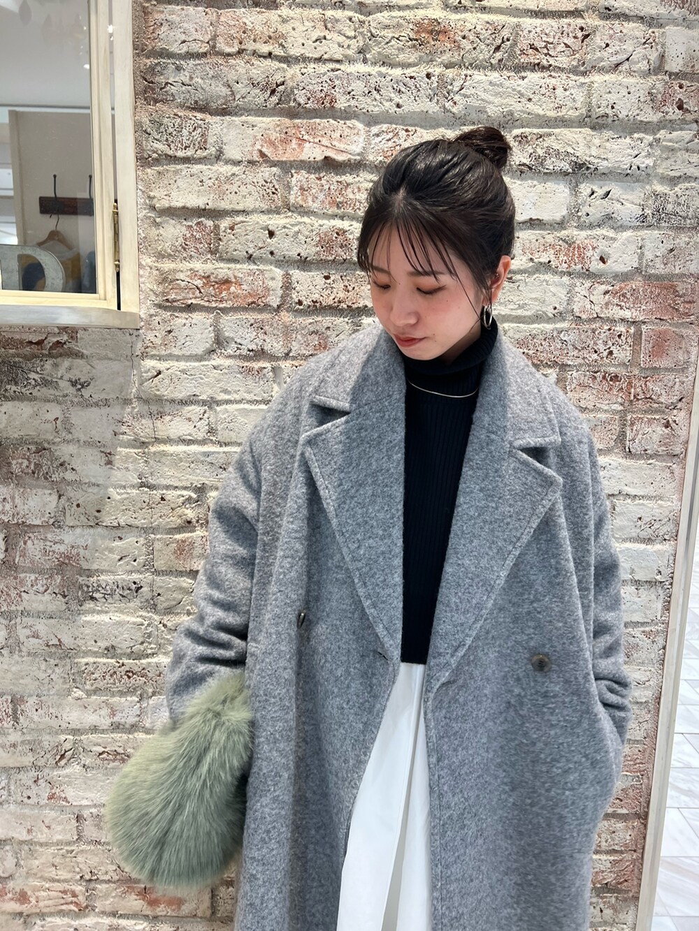 ブラウン系のブーツ、ブラック系のワンピース、グレー系のチェスターコートを着用したレディースの冬コーディネートの10枚目の写真