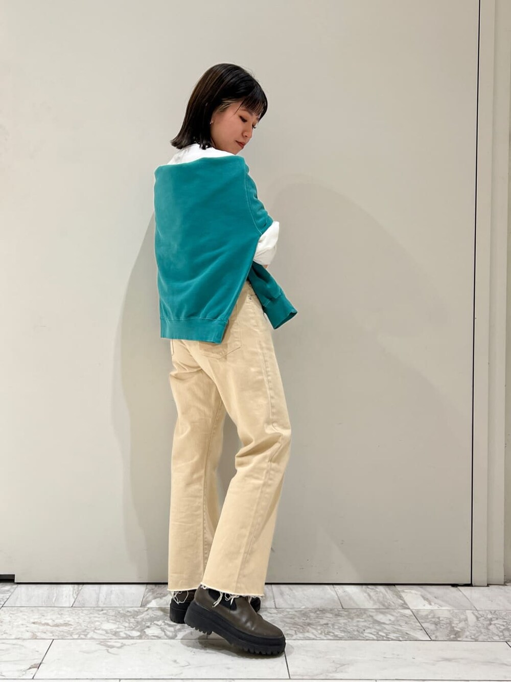 ホワイト系のデニムパンツ、グリーン系のスウェット、ホワイト系のTシャツ/カットソーを着用したレディースの冬コーディネートの5枚目の写真