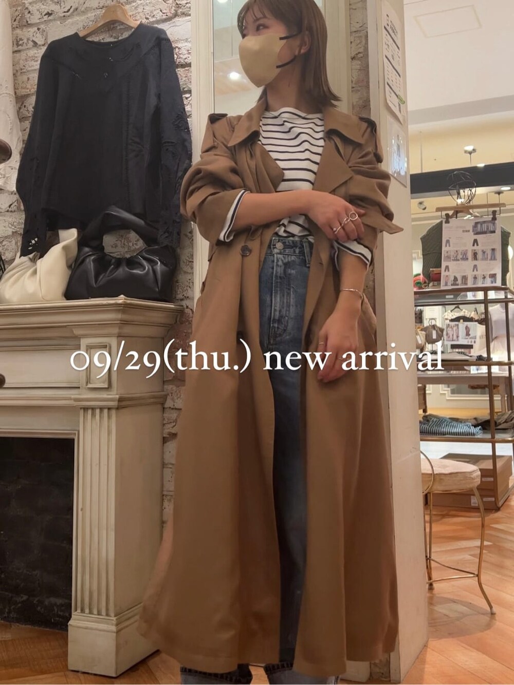 ブルー系のTシャツ/カットソー、イエロー系のトレンチコート、ホワイト系のブーツを着用したレディースの秋コーディネートの5枚目の写真