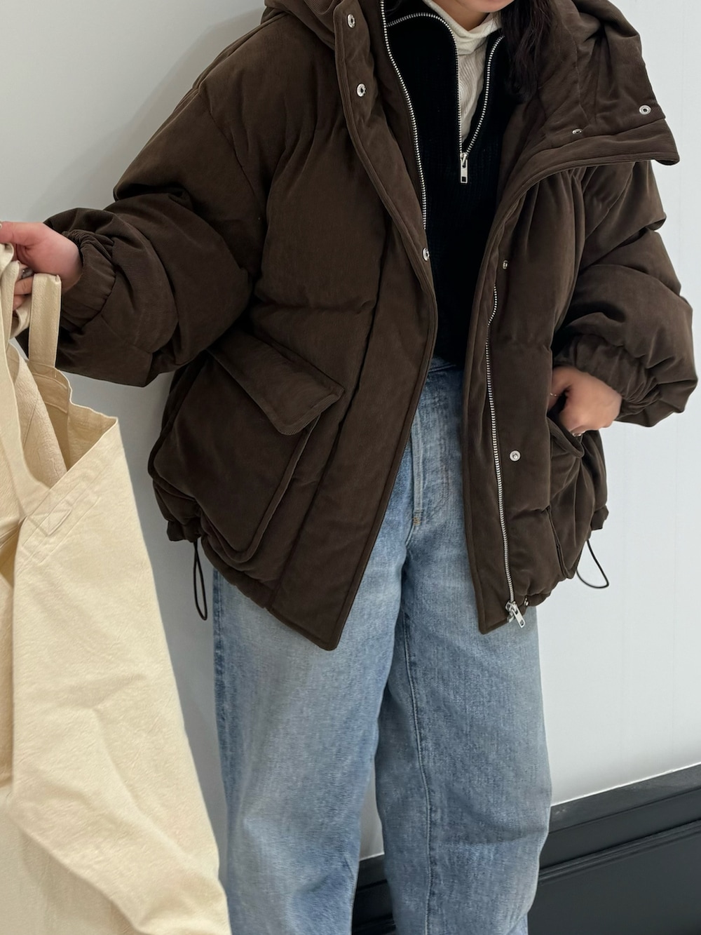 ブルー系のデニムパンツ、ホワイト系のトートバッグ、ホワイト系のTシャツ/カットソーを着用したレディースの冬コーディネートの3枚目の写真