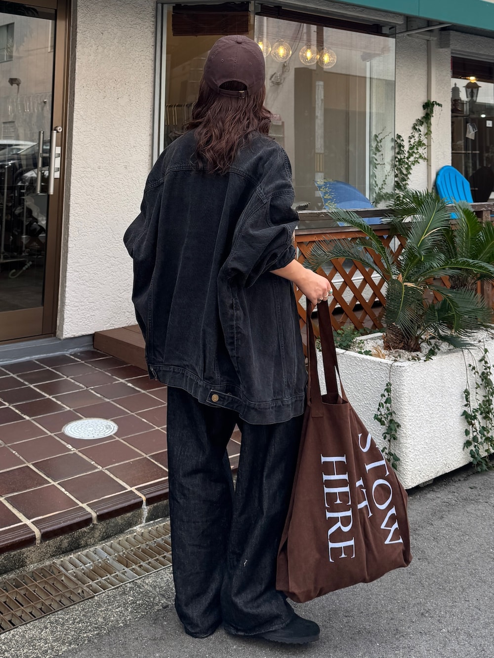 ブラック系のデニムジャケット、ブラック系のデニムパンツ、ブラウン系のトートバッグを着用したレディースの秋コーディネートの5枚目の写真