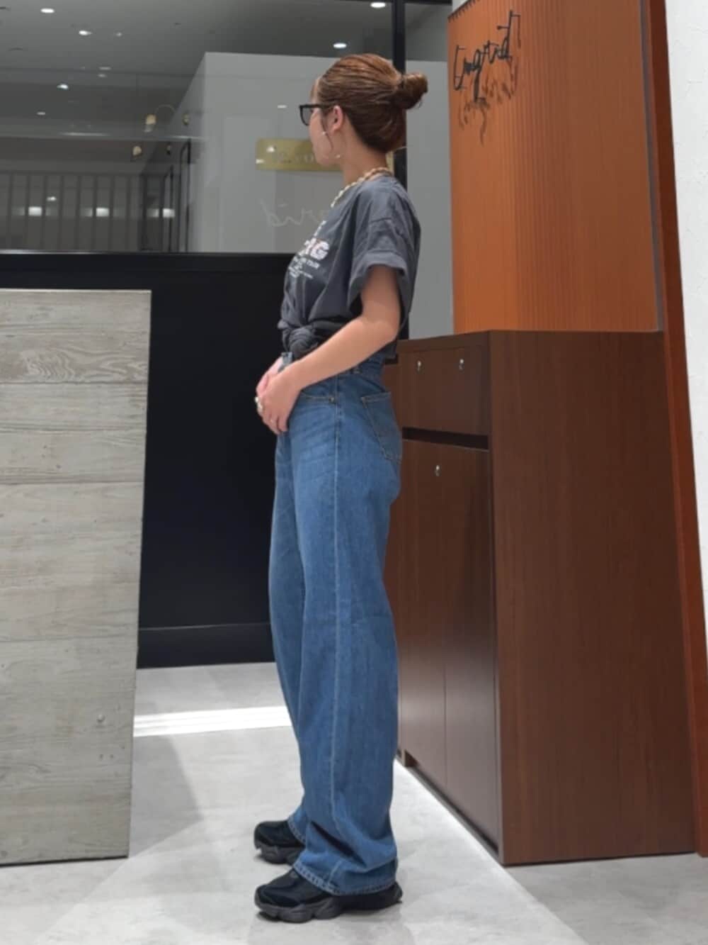 グレー系のTシャツ/カットソー、ブルー系のデニムパンツ、ホワイト系のネックレスを着用したレディースの春コーディネートの3枚目の写真