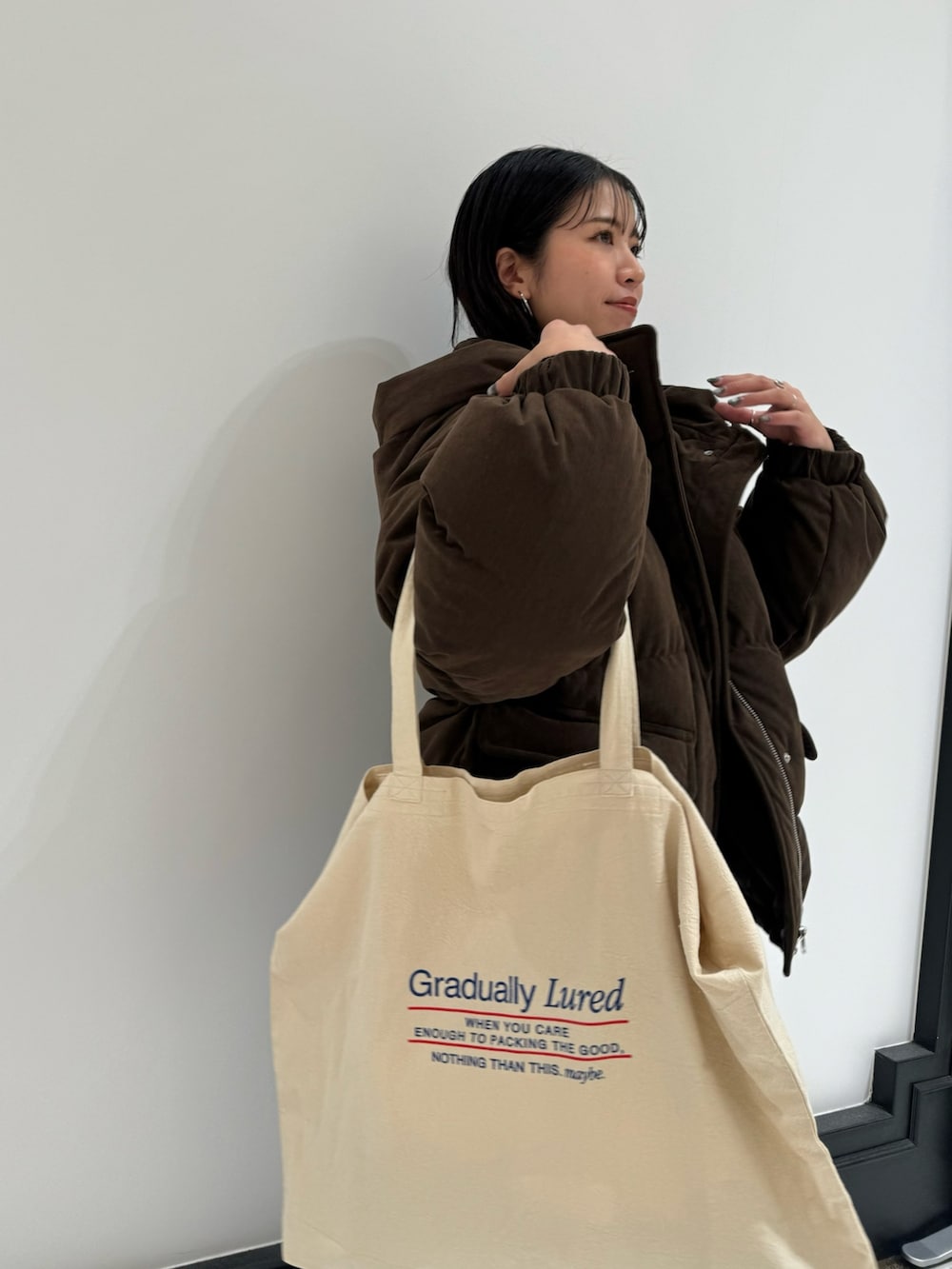 ブルー系のデニムパンツ、ホワイト系のトートバッグ、ホワイト系のTシャツ/カットソーを着用したレディースの冬コーディネートの4枚目の写真