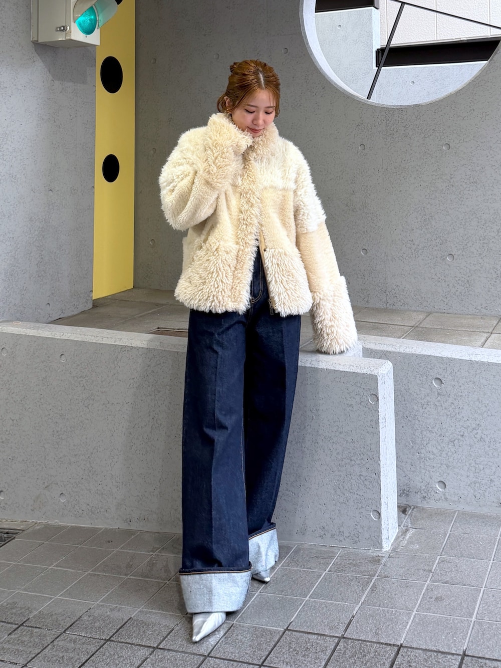 ホワイト系のブルゾン、シルバー系のパンプス、ブルー系のデニムパンツを着用したレディースの秋コーディネートの2枚目の写真
