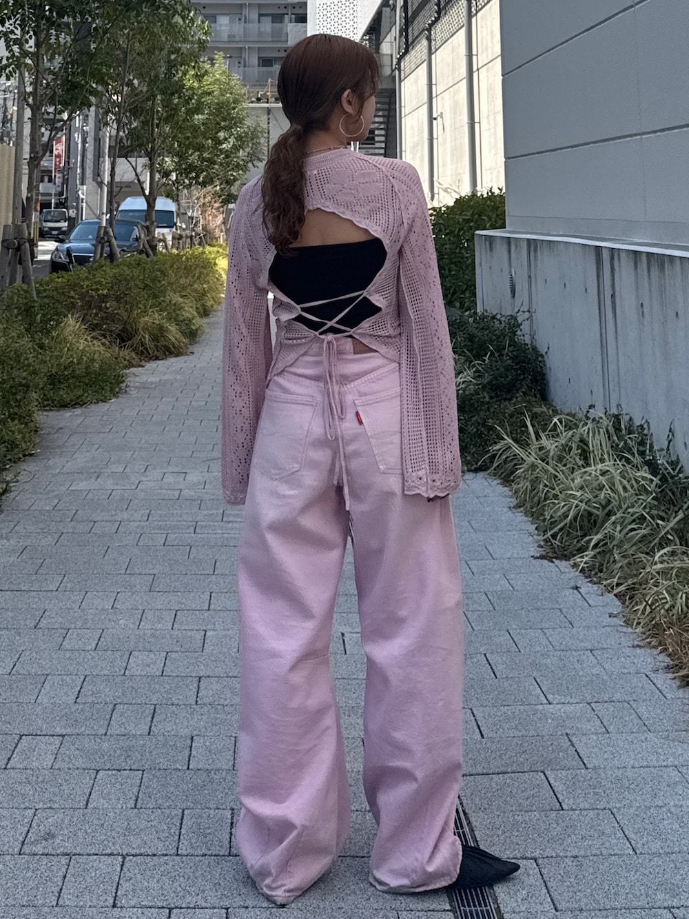 ピンク系のデニムパンツ、ピンク系のニット/セーター、ブラック系のパンプスを着用したレディースの春コーディネートの5枚目の写真