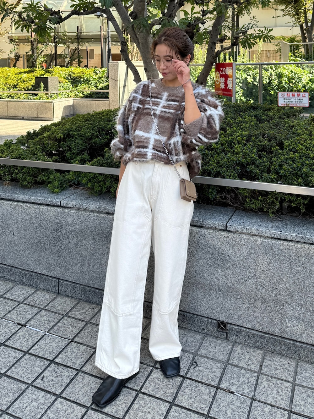 ブラウン系のニット/セーター、ホワイト系のデニムパンツを着用したレディースの秋コーディネートの4枚目の写真