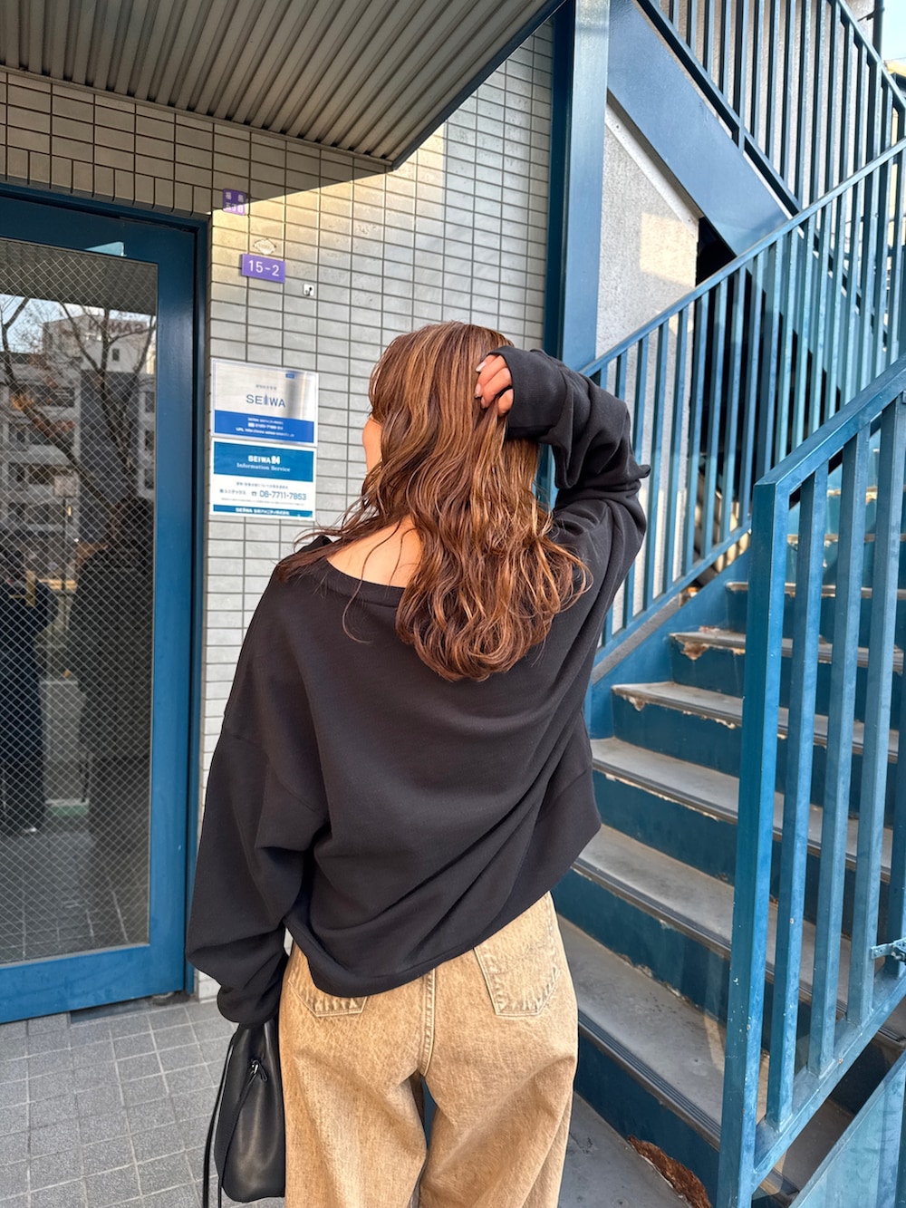 ブラウン系のデニムパンツ、ブラック系のスウェットを着用したレディースの冬コーディネートの9枚目の写真